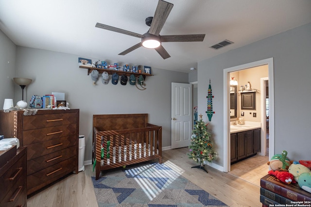 bedroom featuring ensuite bathroom, light hardwood / wood-style flooring, ceiling fan, and sink