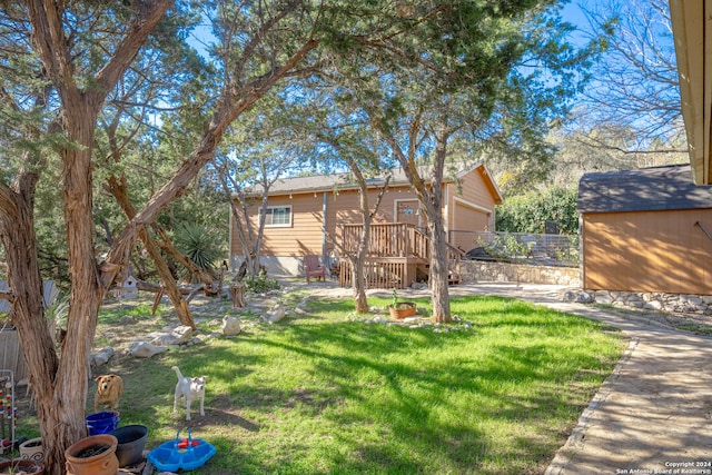 view of yard with a wooden deck and a storage unit