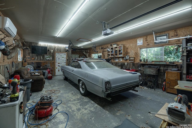 garage featuring a wall unit AC, a workshop area, and a garage door opener