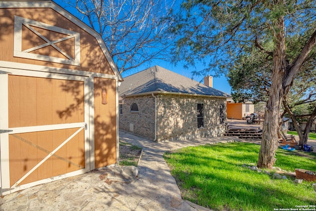 back of property featuring a storage unit, a deck, and a yard