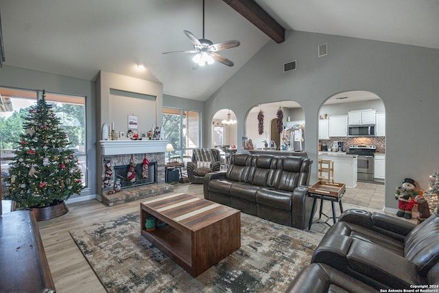 living room featuring a fireplace, light hardwood / wood-style flooring, ceiling fan, and a healthy amount of sunlight