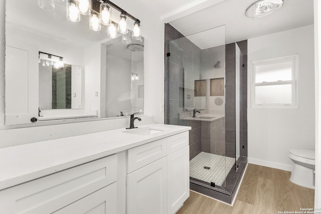 bathroom with toilet, vanity, wood-type flooring, and walk in shower