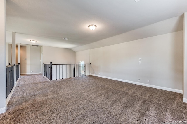 spare room featuring carpet and vaulted ceiling