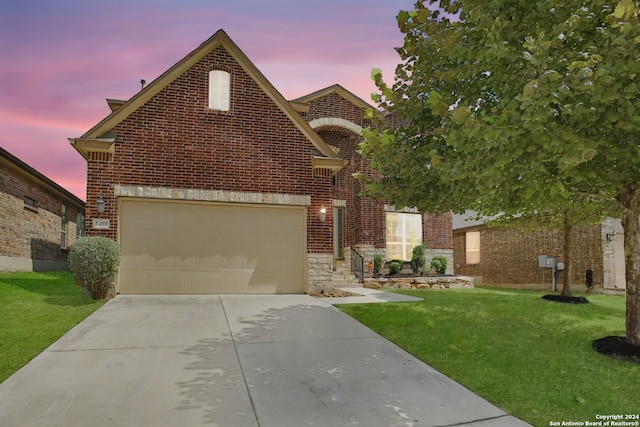 view of front of home with a yard and a garage