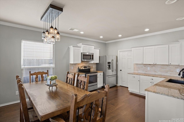 dining room featuring sink, a notable chandelier, dark hardwood / wood-style flooring, and crown molding