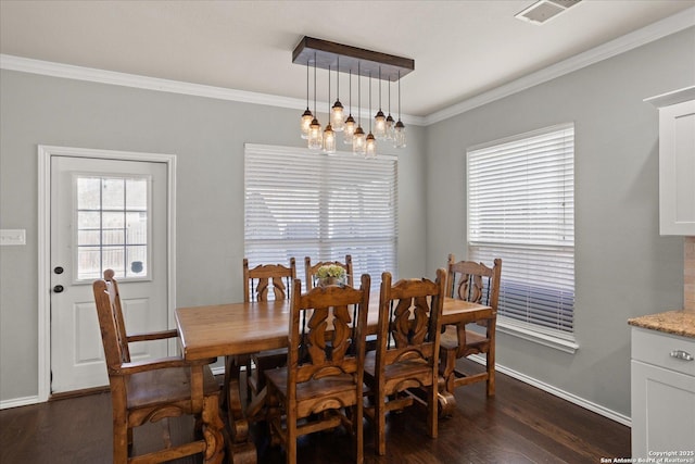 dining room featuring dark hardwood / wood-style floors, ornamental molding, and a chandelier