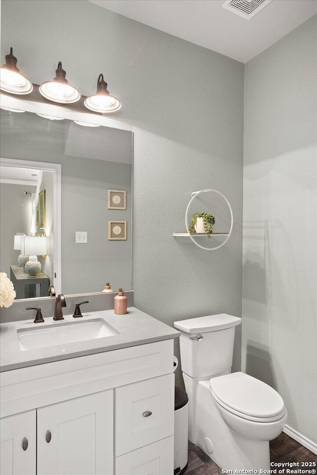 bathroom with vanity, hardwood / wood-style flooring, and toilet