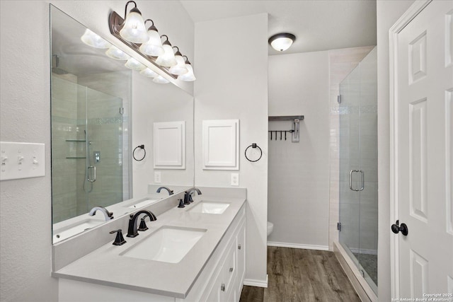 bathroom featuring toilet, vanity, an enclosed shower, and hardwood / wood-style flooring