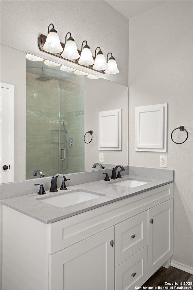 bathroom featuring wood-type flooring, vanity, and an enclosed shower