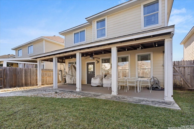 rear view of house featuring a patio area and a yard