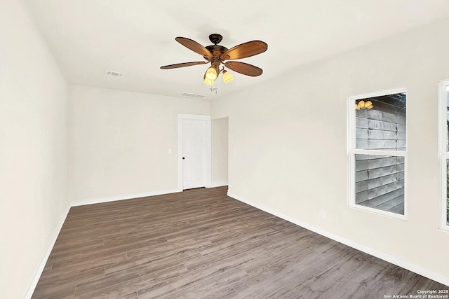 empty room with ceiling fan and dark wood-type flooring