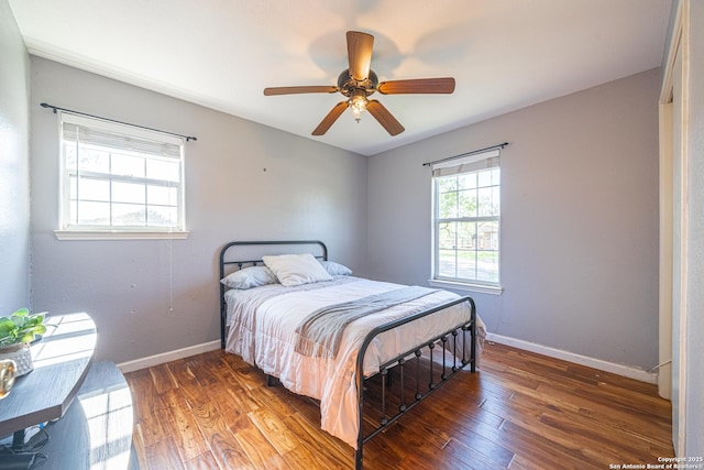 bedroom with ceiling fan and dark wood-type flooring