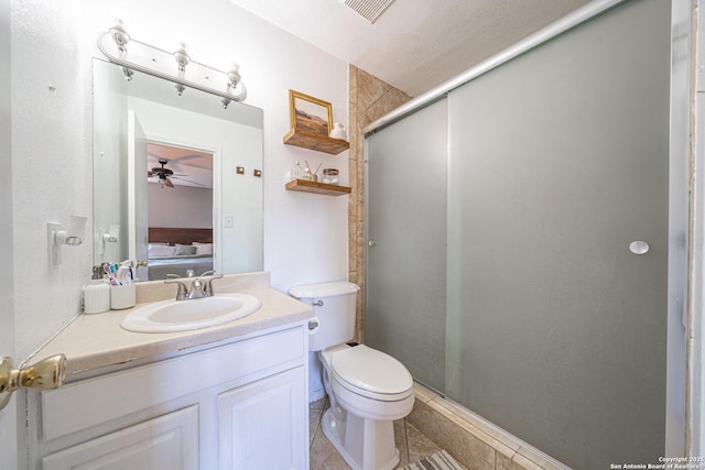 bathroom featuring vanity, toilet, a shower with door, and ceiling fan