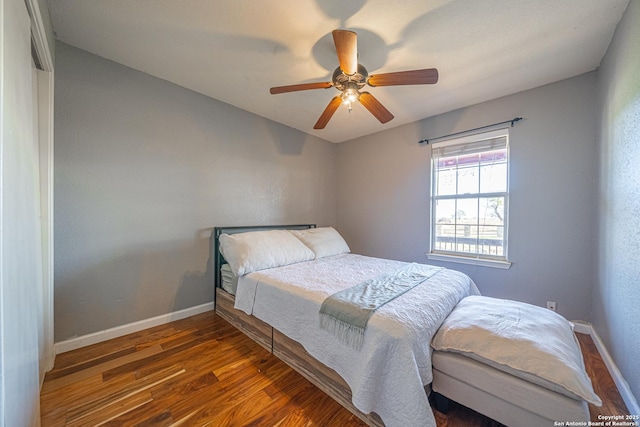 bedroom with dark hardwood / wood-style flooring and ceiling fan