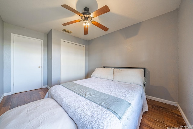 bedroom with a closet, dark hardwood / wood-style floors, and ceiling fan