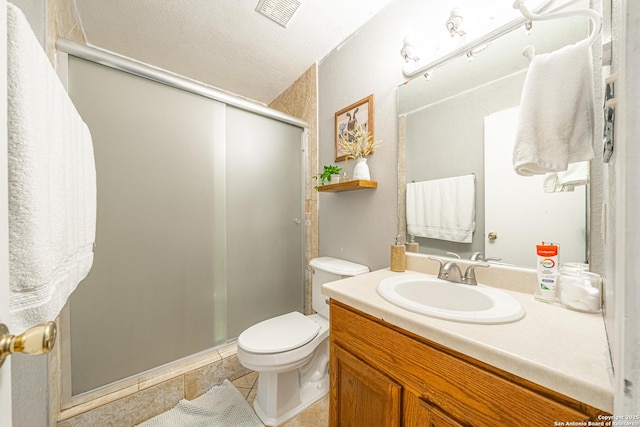 bathroom featuring vanity, tile patterned floors, toilet, a textured ceiling, and a shower with shower door