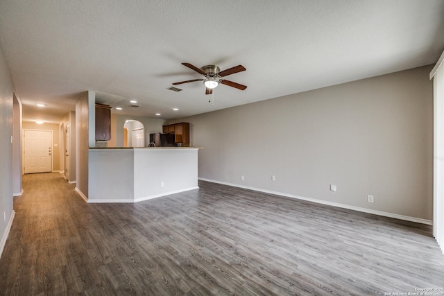 unfurnished living room featuring dark hardwood / wood-style flooring, ceiling fan, and a textured ceiling