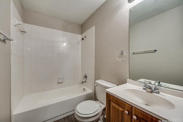 full bathroom featuring wood-type flooring, a textured ceiling, toilet, vanity, and tiled shower / bath