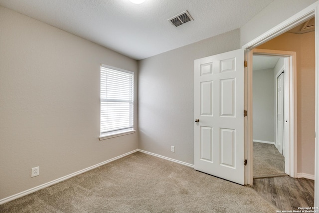 unfurnished bedroom featuring multiple windows and light colored carpet