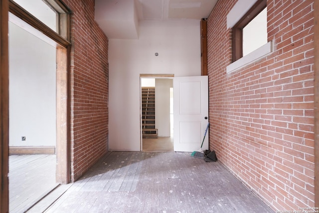 interior space featuring a high ceiling and brick wall