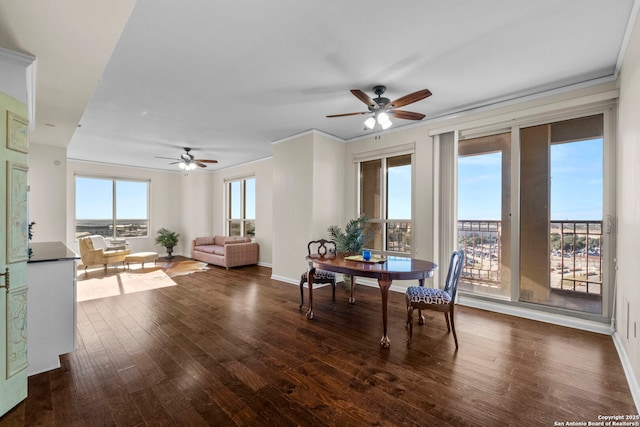 dining area with ceiling fan, ornamental molding, and dark wood-type flooring