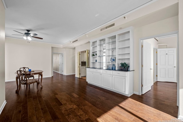 kitchen with dark hardwood / wood-style floors, built in features, ceiling fan, and white cabinetry