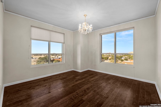 spare room featuring crown molding, hardwood / wood-style floors, and an inviting chandelier