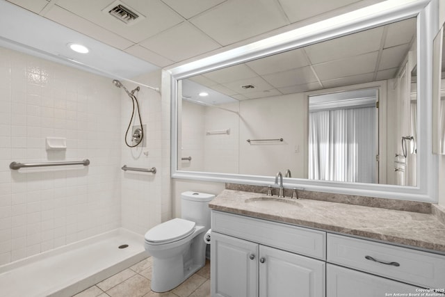 bathroom featuring a tile shower, vanity, toilet, and tile patterned floors