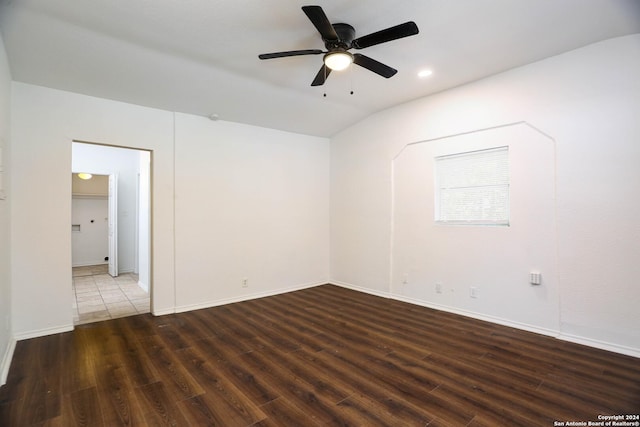 spare room with lofted ceiling, ceiling fan, and dark wood-type flooring