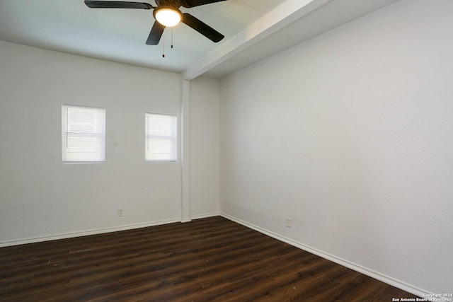 empty room with beamed ceiling, dark hardwood / wood-style flooring, and ceiling fan