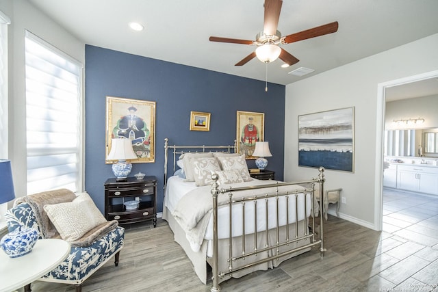 bedroom featuring ensuite bath, ceiling fan, and light hardwood / wood-style flooring