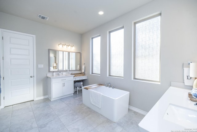 bathroom featuring tile patterned floors, vanity, and a tub to relax in