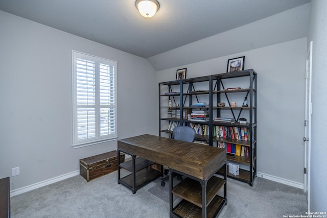 carpeted office space featuring vaulted ceiling