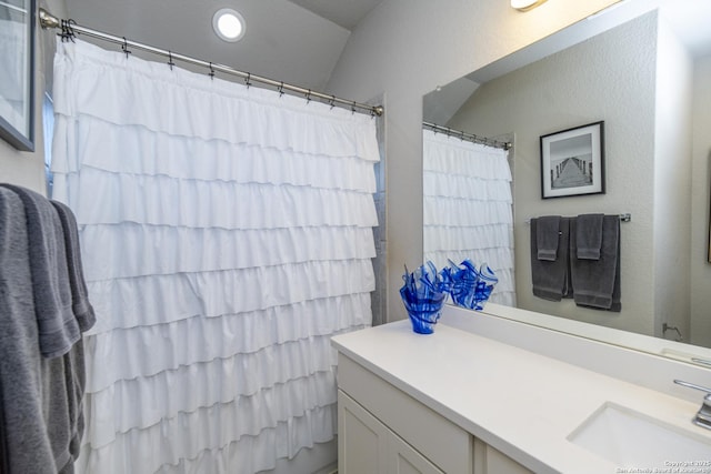 bathroom with vanity, curtained shower, and vaulted ceiling