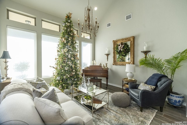 sitting room featuring hardwood / wood-style floors, a notable chandelier, and a towering ceiling