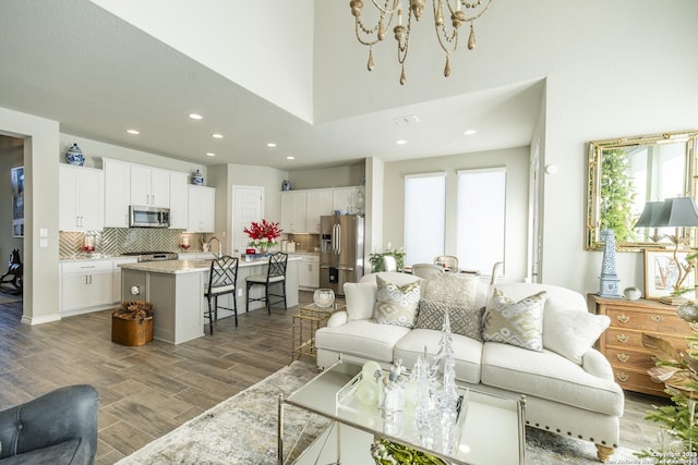 living room with a towering ceiling, sink, and a chandelier