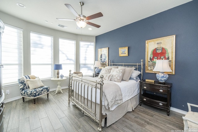 bedroom featuring multiple windows, wood-type flooring, and ceiling fan