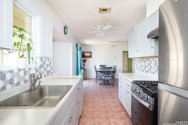 kitchen with appliances with stainless steel finishes, white cabinetry, and sink