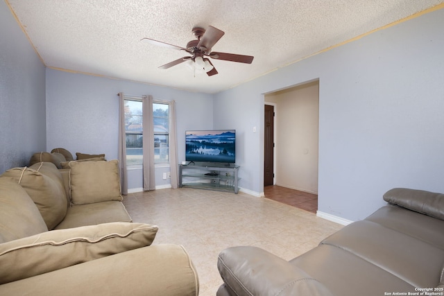 living room featuring ceiling fan and a textured ceiling