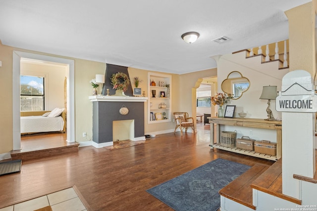 interior space featuring built in shelves and wood-type flooring