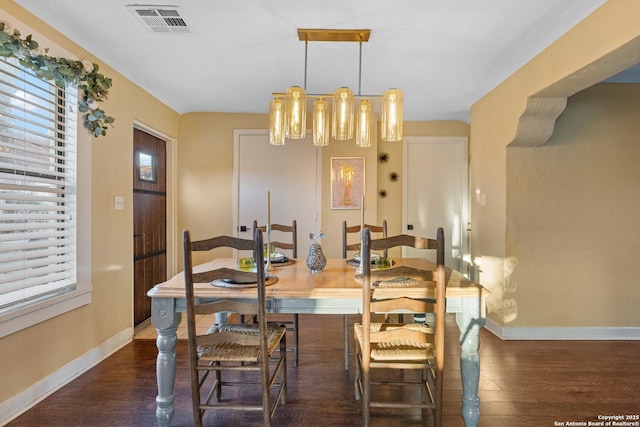 dining room featuring dark hardwood / wood-style floors and a chandelier