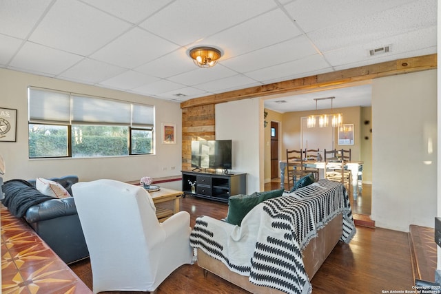 living room with a drop ceiling and dark hardwood / wood-style floors