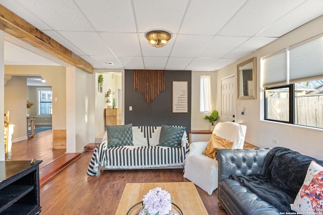 living room with a drop ceiling and dark wood-type flooring