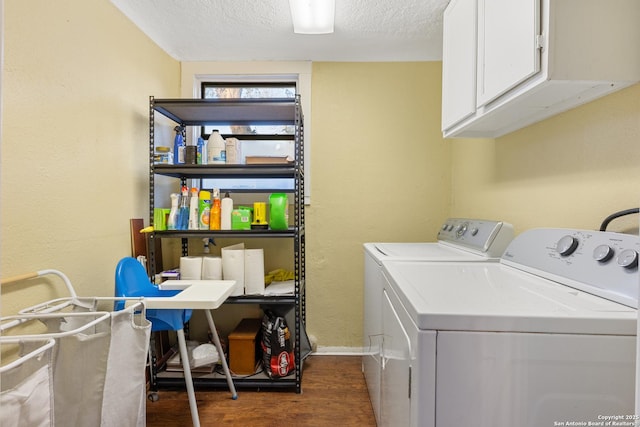 laundry room featuring cabinets, independent washer and dryer, a textured ceiling, and dark wood-type flooring