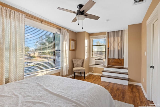 bedroom featuring ceiling fan, cooling unit, and dark wood-type flooring