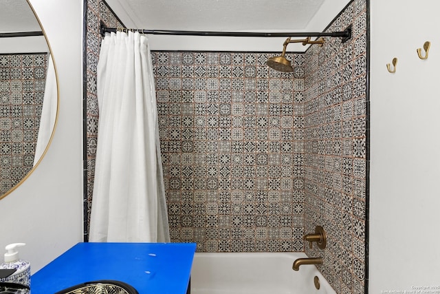 bathroom featuring shower / bathtub combination with curtain and a textured ceiling