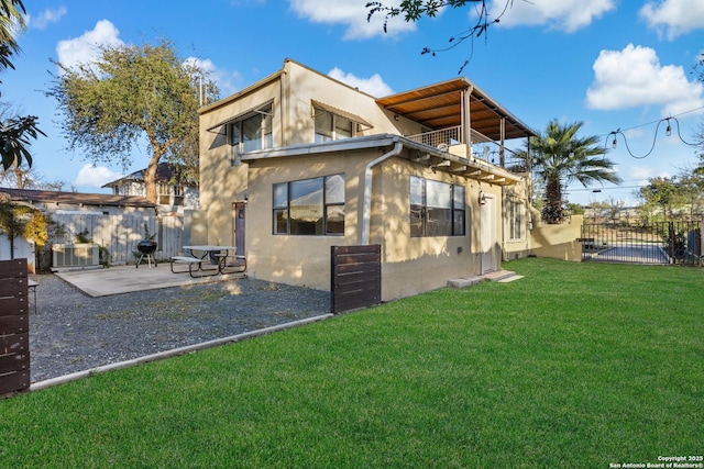 rear view of house with a yard and a balcony