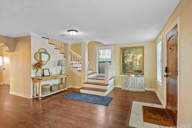 foyer entrance featuring dark hardwood / wood-style flooring and a textured ceiling