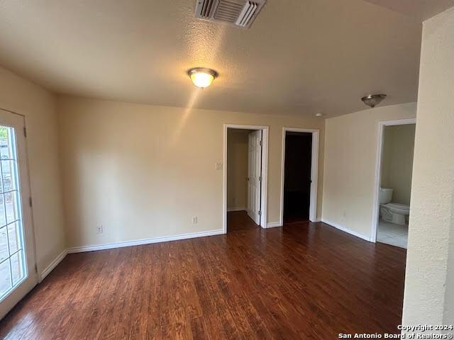 spare room featuring plenty of natural light, dark hardwood / wood-style flooring, and a textured ceiling