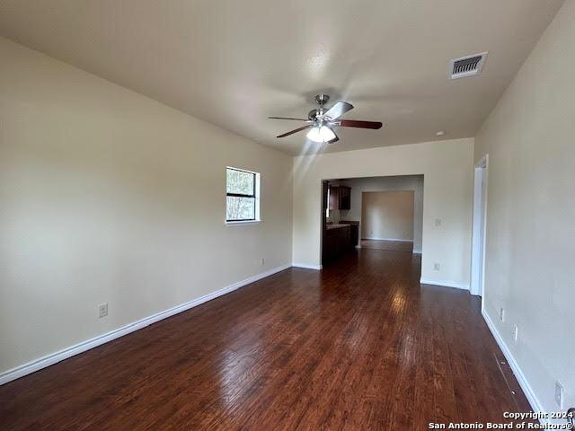 unfurnished room featuring ceiling fan and dark hardwood / wood-style flooring